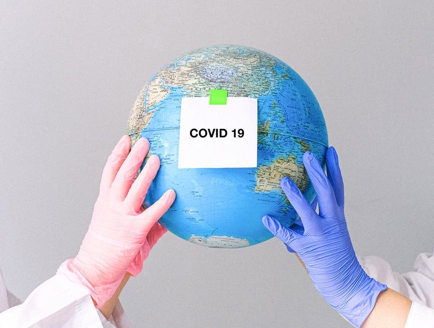 hands with latex gloves holding a globe